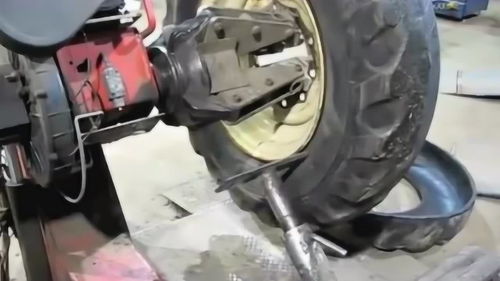 國外修車廠給拖拉機(jī)更換外胎的拆胎操作